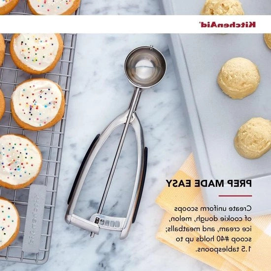 Spazzola per biscotti in acciaio inossidabile con maniglie nere.
