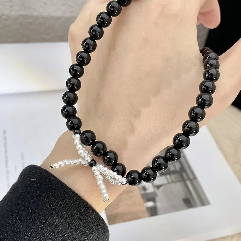 Collana con fiocco in corda nera e perline: regalo fatto a mano per donna.