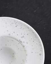 Servizio di piatti in ceramica a due colori, grigio e bianco.