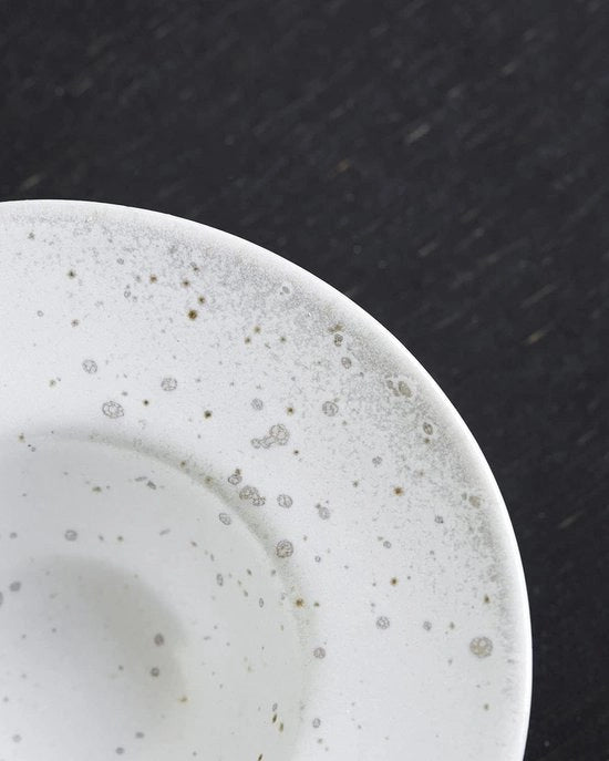Servizio di piatti in ceramica a due colori, grigio e bianco.