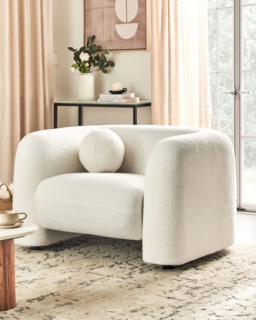 Poltrona in tessuto bouclè bianco con cuscino rotondo stile glamour retrò soggiorno