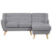 Divano ad angolo grigio chiaro imbottito con schienale capitonnè Chaise longue con gambe in legno chiaro Soggiorno minimalista scandinavo