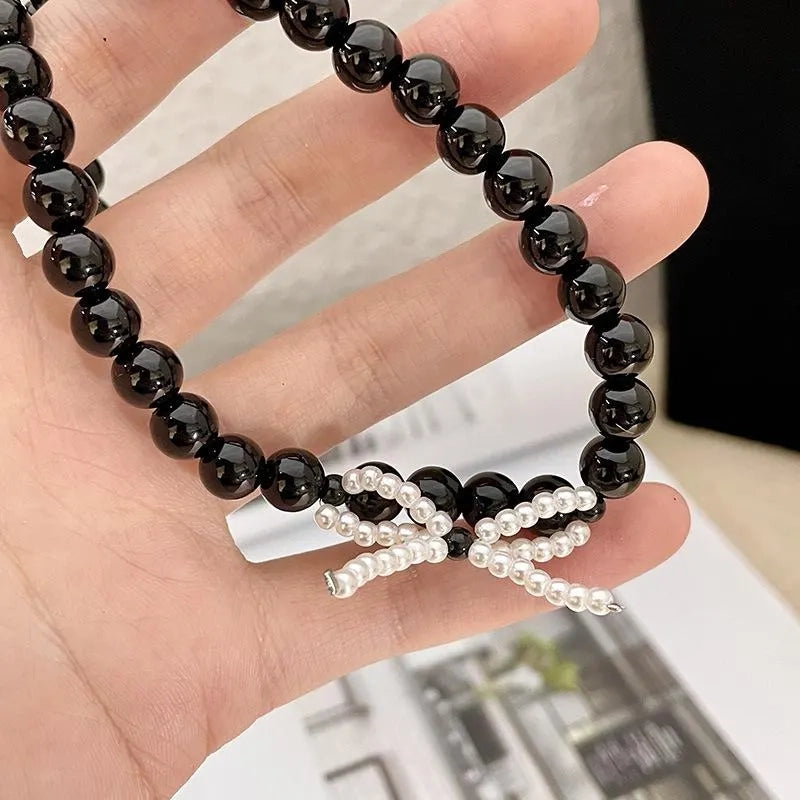 Collana con fiocco in corda nera e perline: regalo fatto a mano per donna.