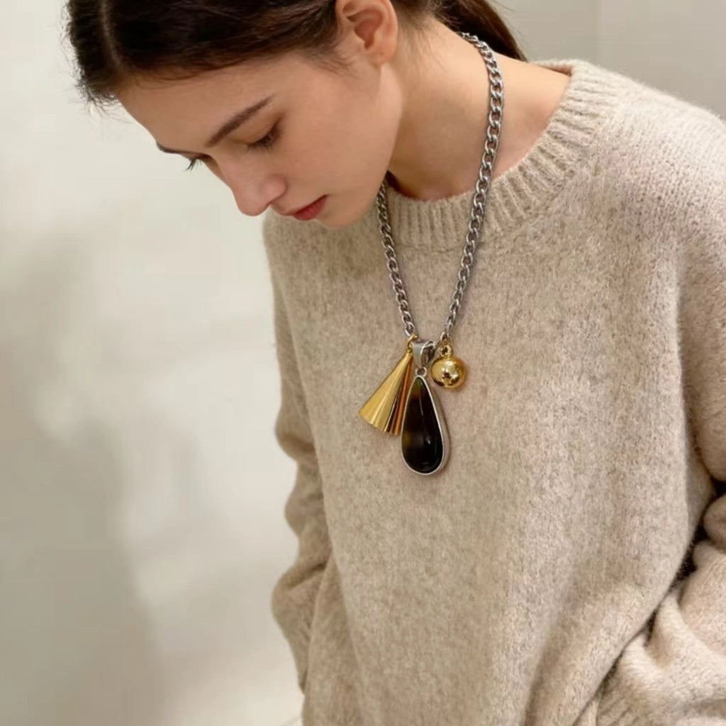 Collana vintage con pendente a goccia d'ambra e lunga catena marrone da donna.