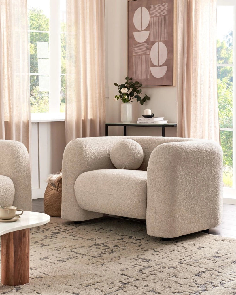 Poltrona in tessuto bouclè beige bianco con cuscino rotondo stile glamour retrò soggiorno