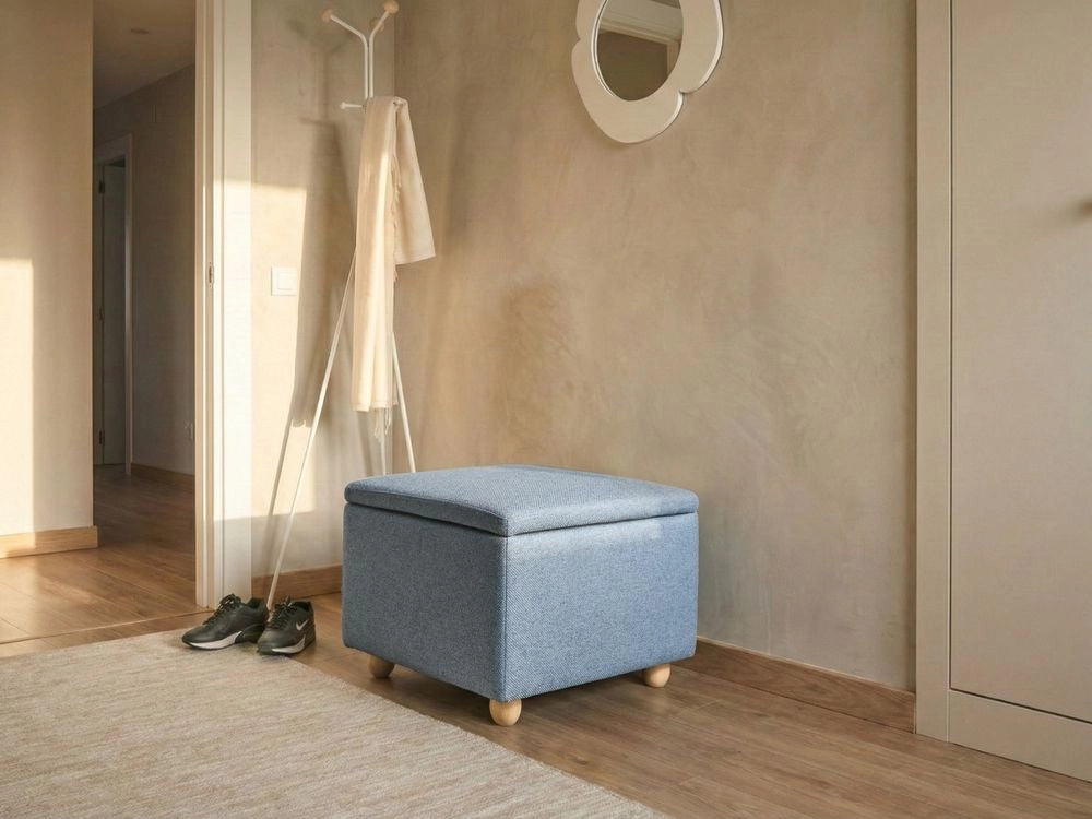 Pouf contenitore in tessuto blu con finitura idrorepellente. Poggiapiedi imbottito con contenitore e seduta per ingresso.