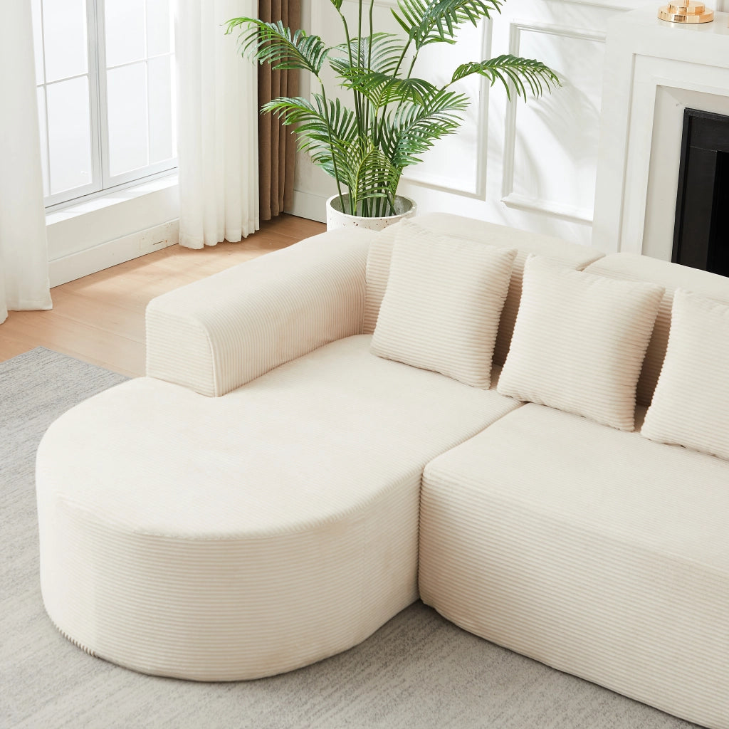Divano angolare a L con chaise longue; braccioli curvi e cuscini in velluto a coste beige