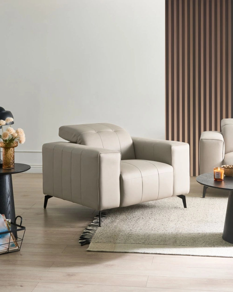 Poltrona in ecopelle beige chiaro  con poggiatesta regolabile e gambe in metallo stile moderno