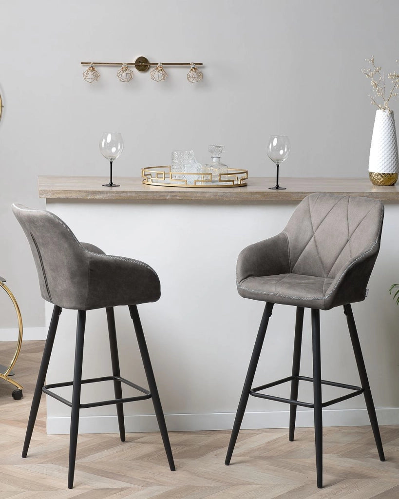 Set di 2 sgabelli da bar rivestiti in tessuto grigio con braccioli schienale trapuntato gambe in metallo Nero