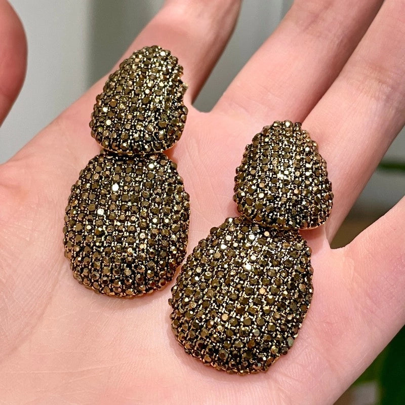 Design lussuoso e sofisticato, orecchini geometrici a forma di goccia con dettagli in diamanti.
