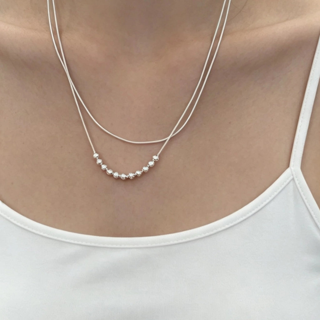 Elegante e semplice collana a doppio strato di perline d'argento in stile francese per donna, un accessorio di nicchia, lussuoso ma versatile, perfetto da indossare a strati o come catena per la clavicola.