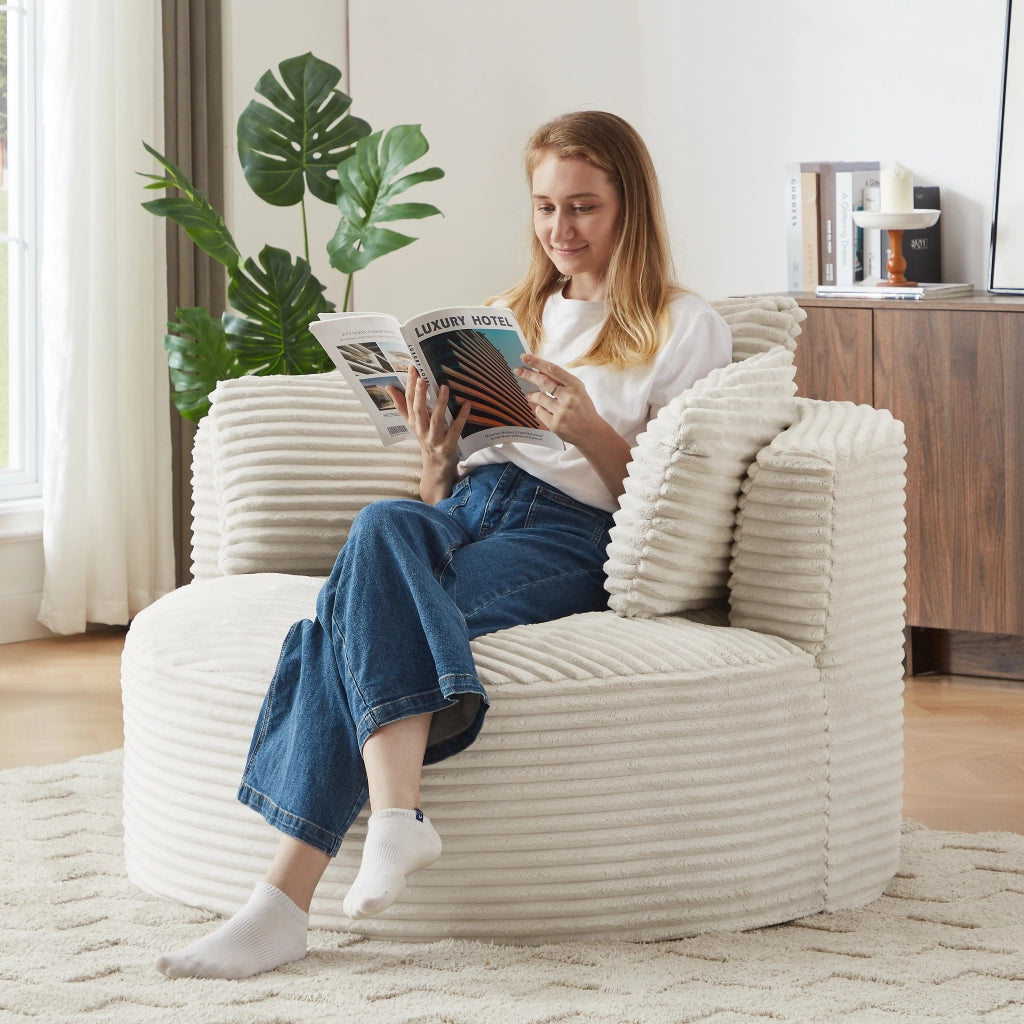 Poltrona rotonda imbottita con schienale ergonomico e supporto a molle insacchettate in velluto a coste beige