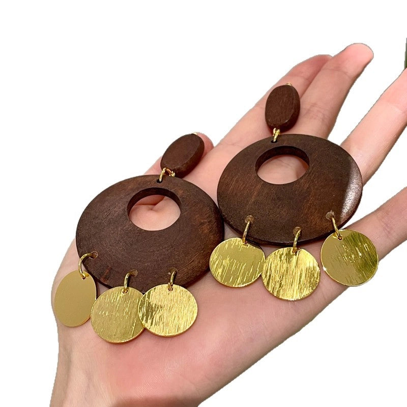 Orecchini vintage rotondi in legno traforato con nappe a disco in metallo spazzolato