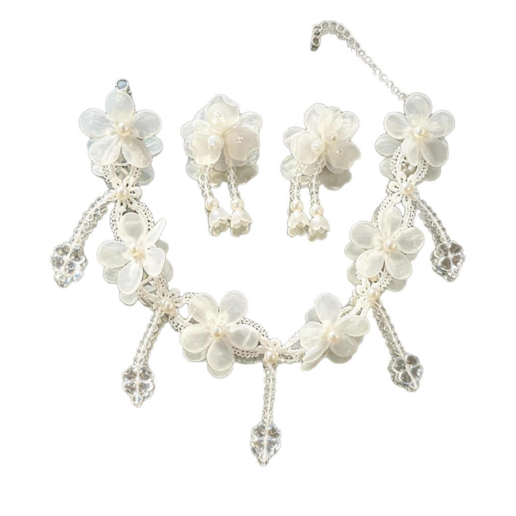 Collana fatta a mano con fiore in pizzo bianco, perle e nappe di cristallo.