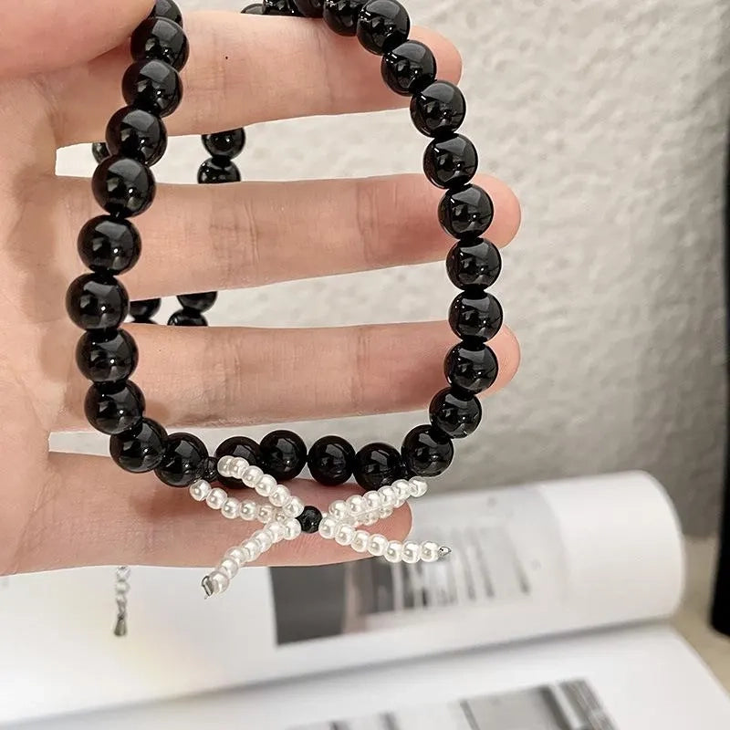 Collana con fiocco in corda nera e perline: regalo fatto a mano per donna.