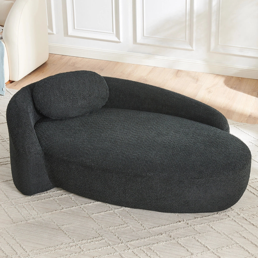 Divano minimalista in Teddy nero; morbido con cuscino testa; design arrotondato