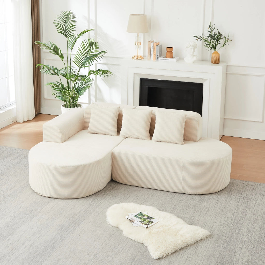 Divano angolare a L con chaise longue; braccioli curvi e cuscini in velluto a coste beige
