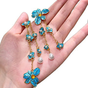 Orecchini pendenti con perle di cristallo a forma di petalo blu.