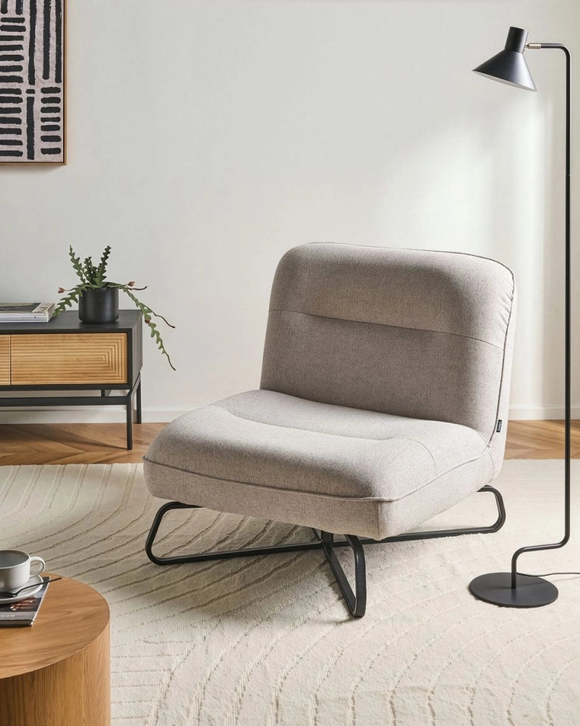 Poltrona in tessuto beige, seduta ampia, senza braccioli, struttura in metallo nero, complemento d'arredo moderno per il soggiorno