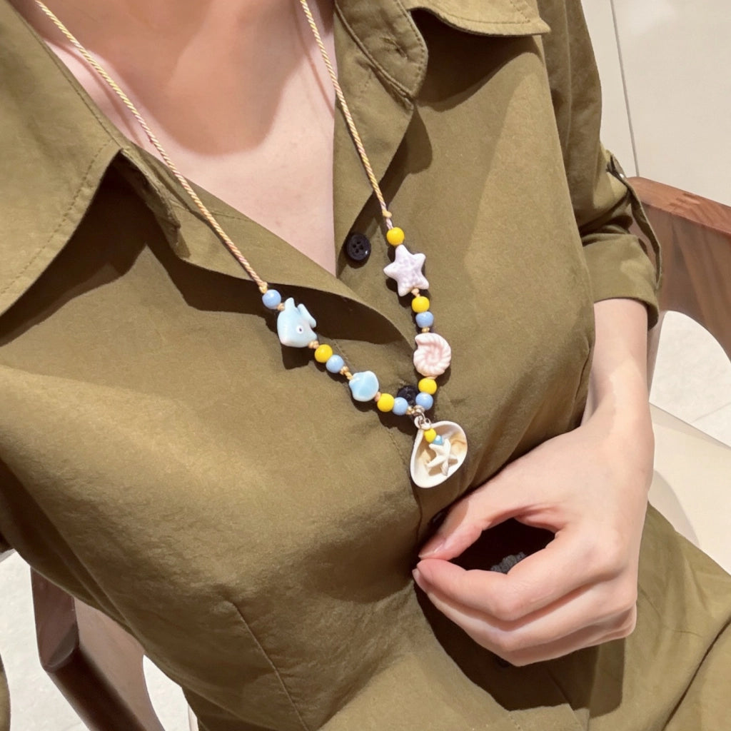 Collana con ciondolo a forma di stella marina e conchiglia, ricca di dopamina.