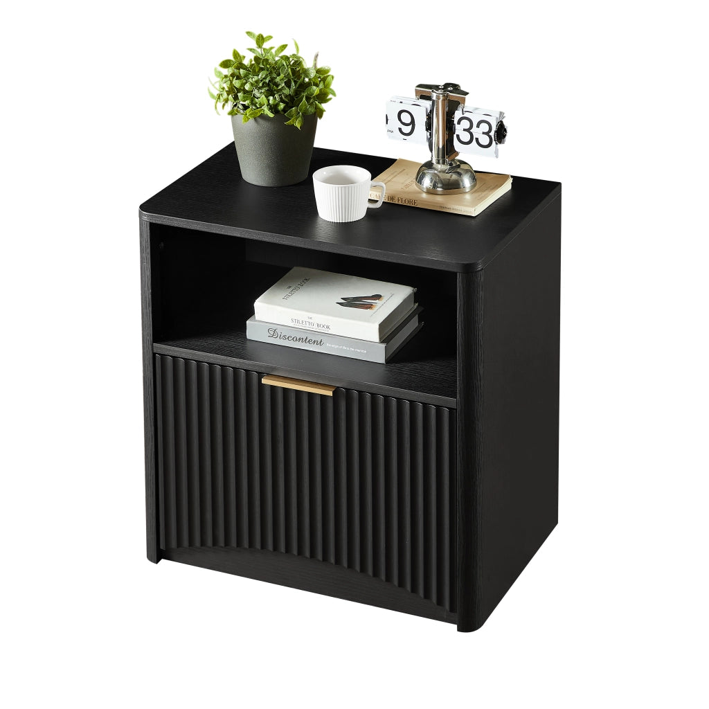 Comodino moderno in truciolare nero con cassetto aperto, maniglia dorata e design scanalato