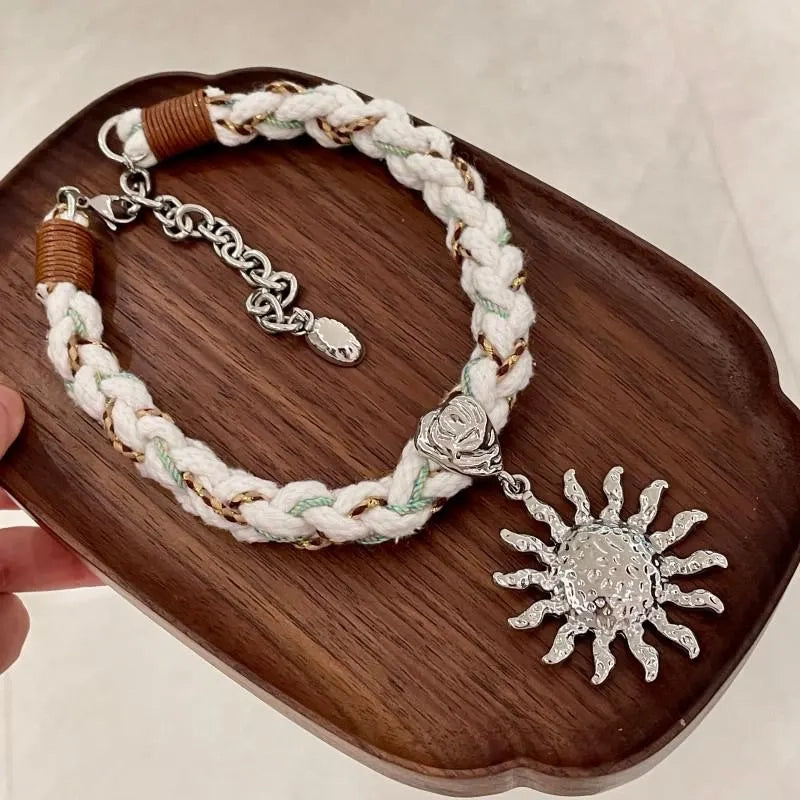 Collana con ciondolo a forma di sole intrecciato a mano
