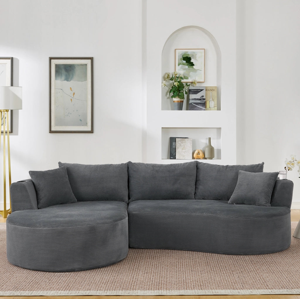 Divano a 3 posti dal design curvo in tessuto corduroy grigio; con portabicchieri e cuscini