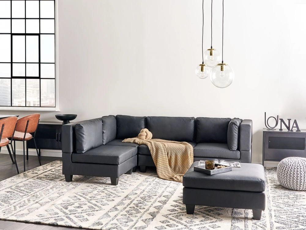Divano componibile 4 posti imbottito in tessuto nero con gambe nere schienale imbottito lato destro con pouf stile moderno