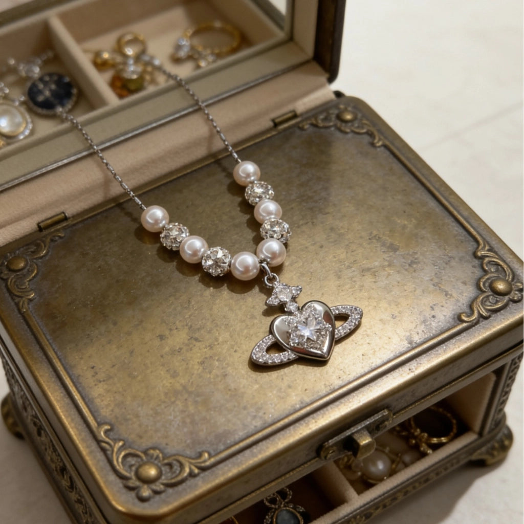 Collana con pianeta a forma di cuore in zircone, ciondolo di Saturno e catena di perle per la clavicola.
