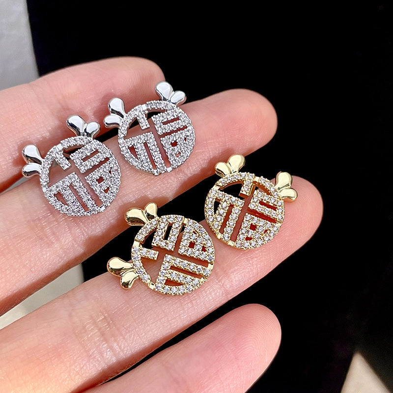Orecchini a spillo in argento sterling S925 con cuore in zirconi microincastonati e disegno traforato del carattere "Fu".