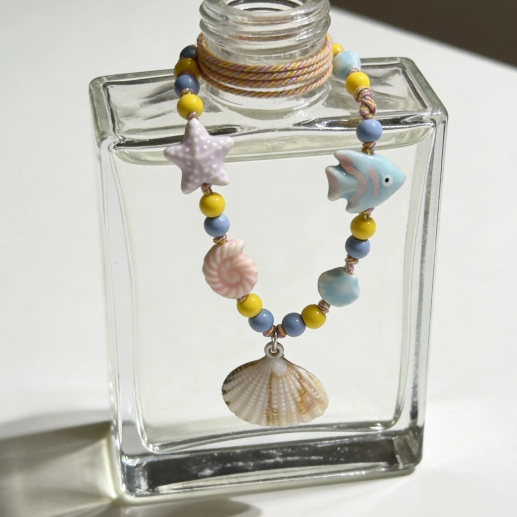 Collana con ciondolo a forma di stella marina e conchiglia, ricca di dopamina.