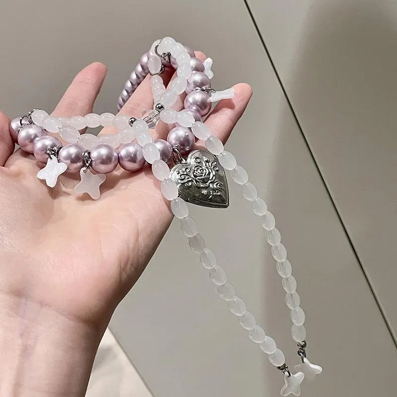 Collana con fiocco fatta a mano con perle rosa e viola.