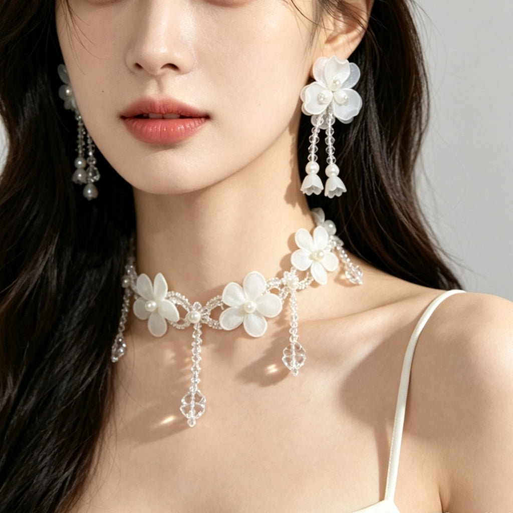 Collana fatta a mano con fiore in pizzo bianco, perle e nappe di cristallo.