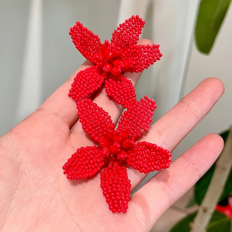 Orecchini a forma di fiore con perline rosse intrecciate a mano
