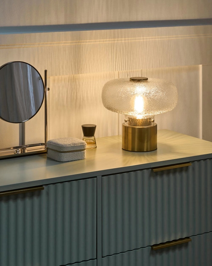 Lampada da tavolo con base in ottone e paralume in vetro testurizzato trasparente; design moderno e glamour per il soggiorno