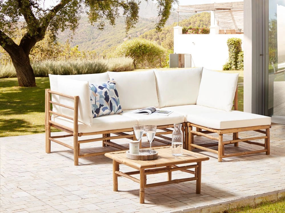 Set da giardino angolare composto da divano 2 posti 2 poltrone e tavolino in bambù bianco sporco con cuscini bianchi stile elegante esterno