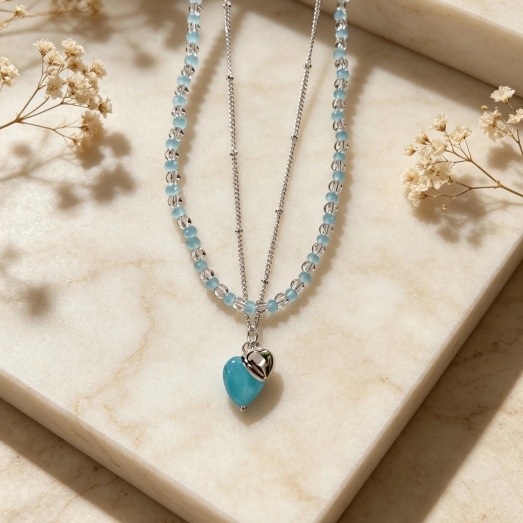 Collana girocollo a doppio strato con perline a forma di cuore blu, design unico.