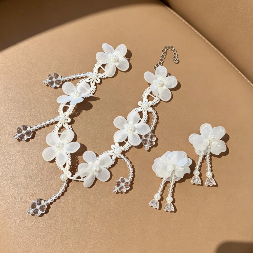 Collana fatta a mano con fiore in pizzo bianco, perle e nappe di cristallo.