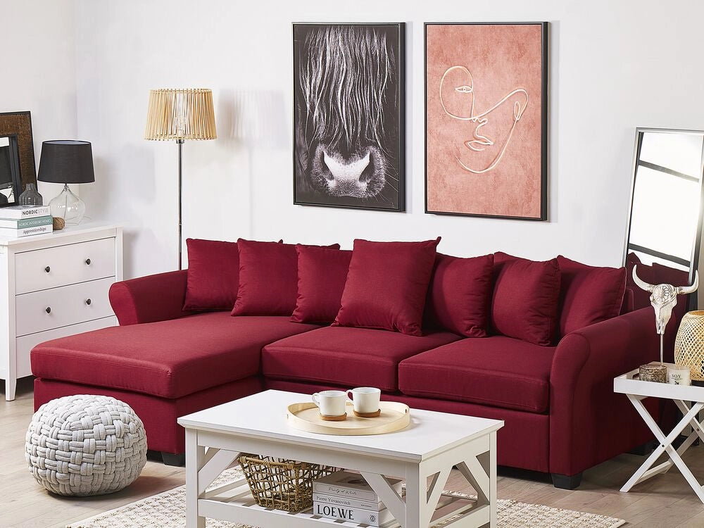 Divano ad angolo in tessuto rosso scuro con gambe nere in stile minimalista. Soggiorno