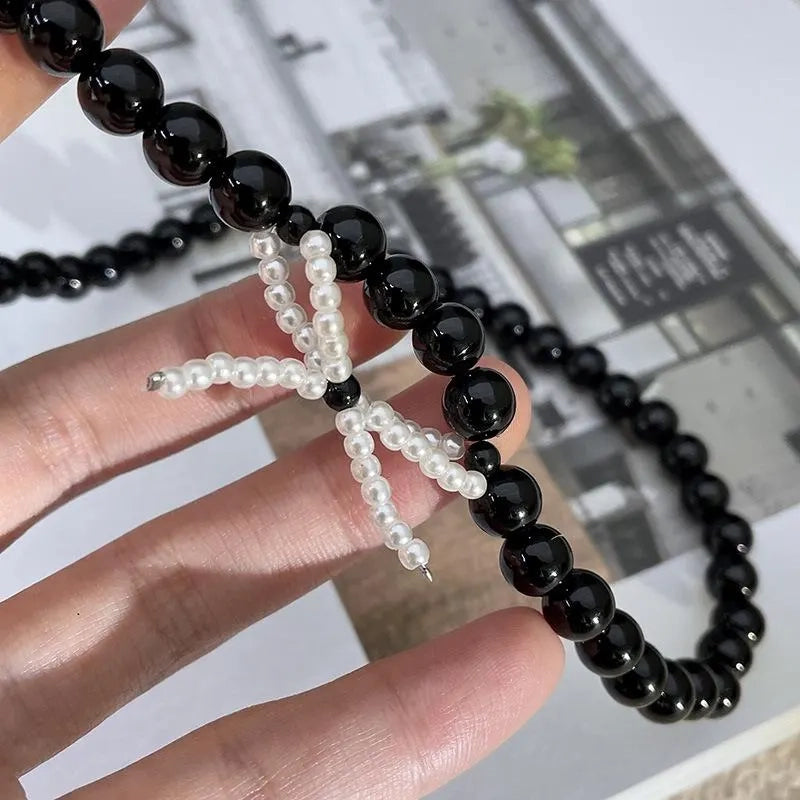 Collana con fiocco in corda nera e perline: regalo fatto a mano per donna.