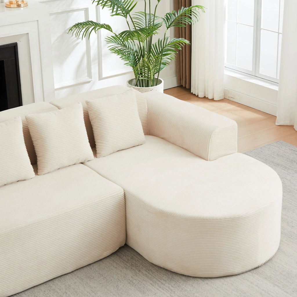 Divano modulare a L beige in velluto a coste con forme curve