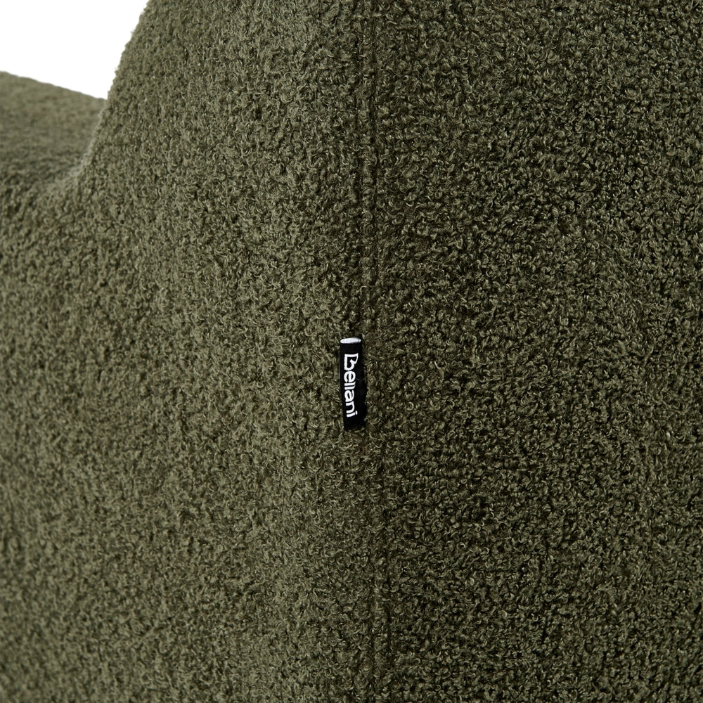 Poltrona con rivestimento in bouclé verde scuro schienale imbottito e cuscini spessi perfetta per un soggiorno moderno