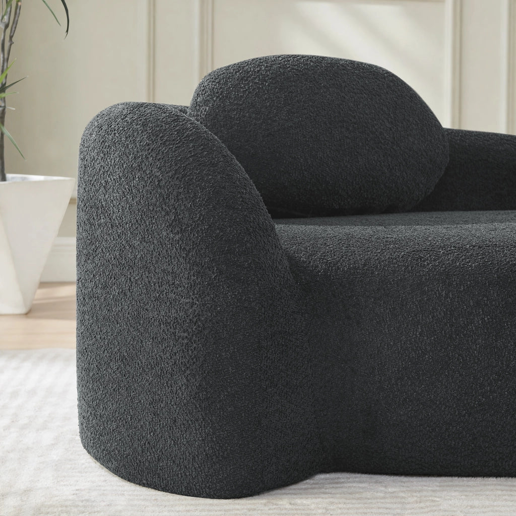 Divano minimalista in tessuto Teddy nero, imbottitura morbida e design salvaspazio