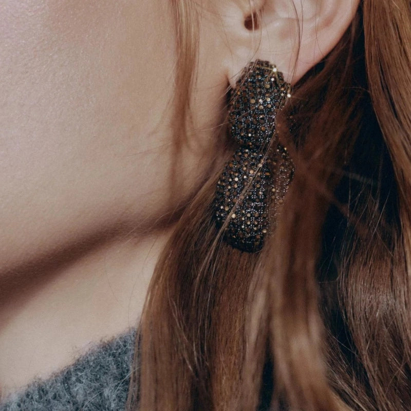 Design lussuoso e sofisticato, orecchini geometrici a forma di goccia con dettagli in diamanti.