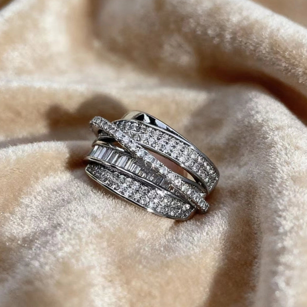Anello di nicchia di alta gamma con linee intersecanti in argento e zirconi