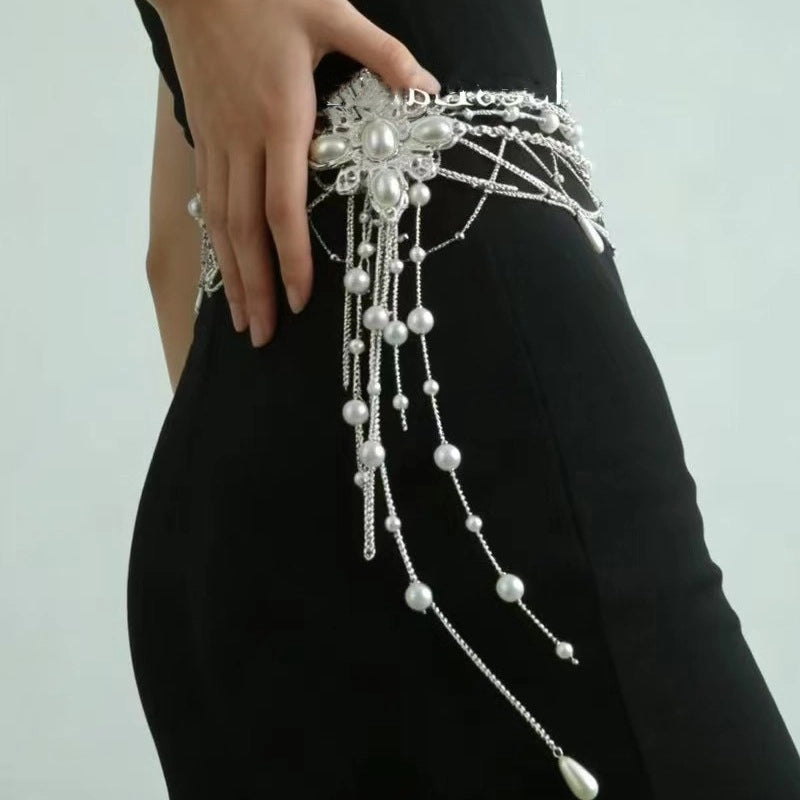 Cintura da donna con catena a croce e fiore di perla e nappe di perline.