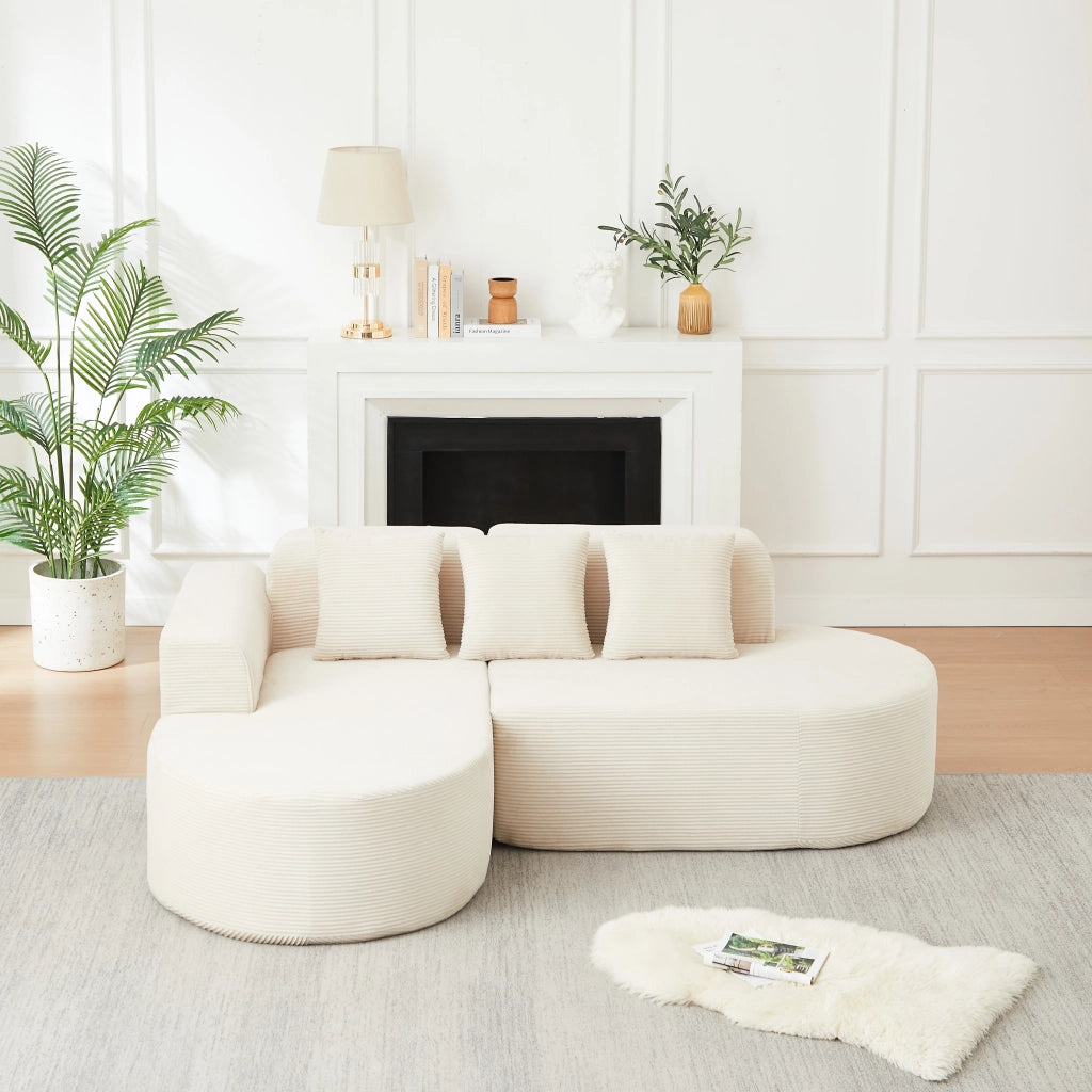 Divano angolare a L con chaise longue; braccioli curvi e cuscini in velluto a coste beige