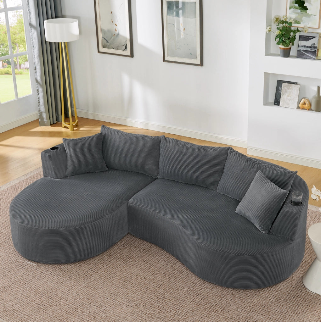 Divano a 3 posti dal design curvo in tessuto corduroy grigio; con portabicchieri e cuscini