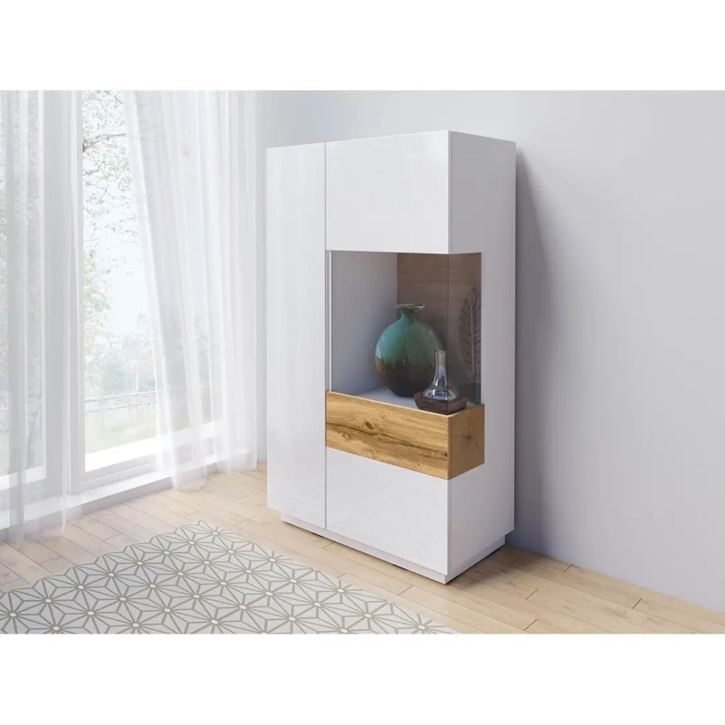 Credenza alta collezione KILES con due porte. Colori bianco e rovere. Porta a vetro a destra.