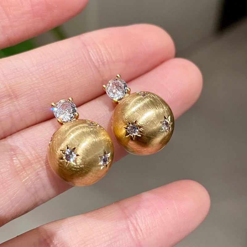 Piccoli e unici orecchini a lobo con zirconi spazzolati a forma di stella.